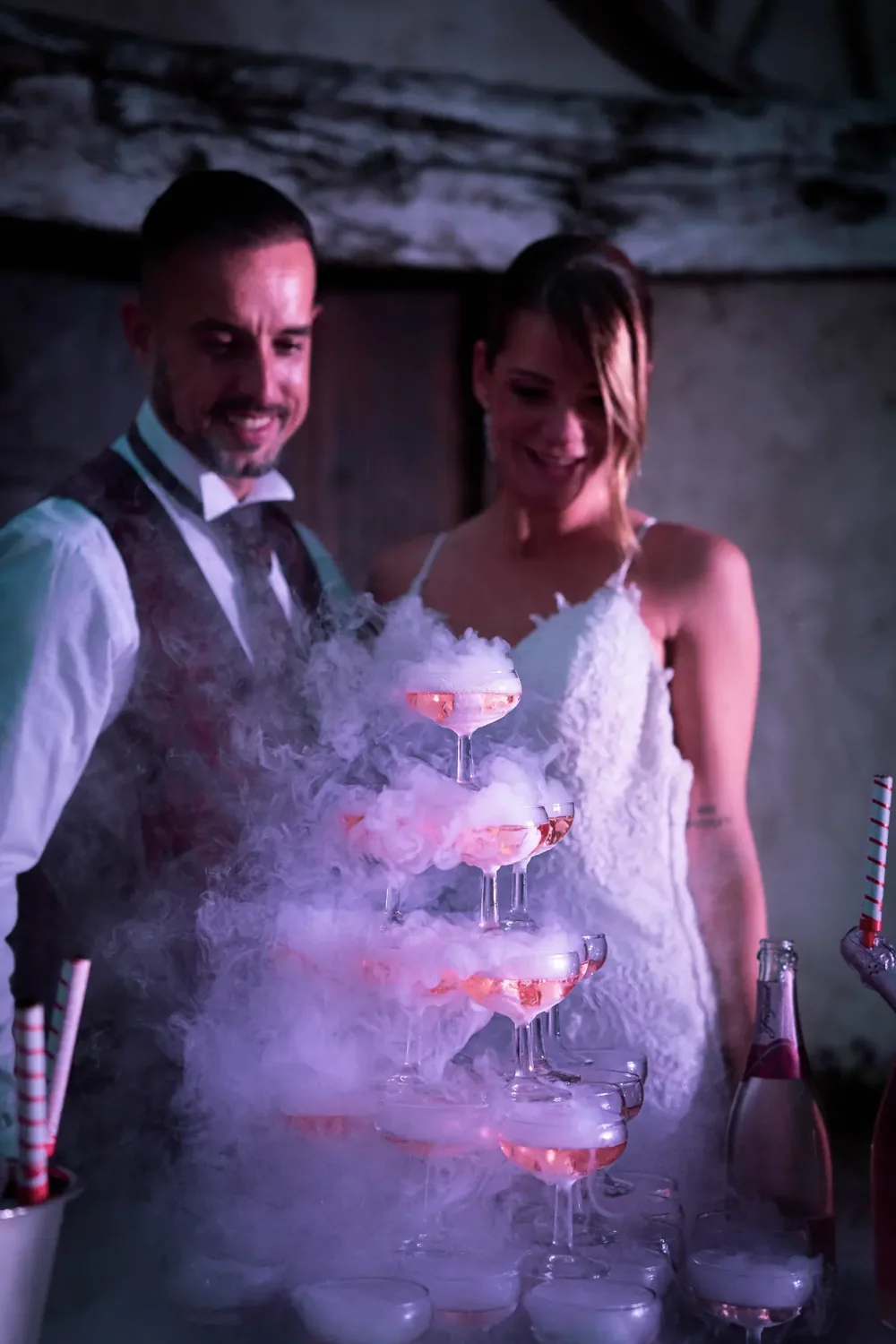Pareja brindando ante una torre de copas humeante